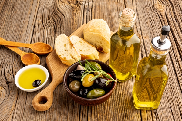 high angle olives mix bread and oil bottles - Закуска с маслинами