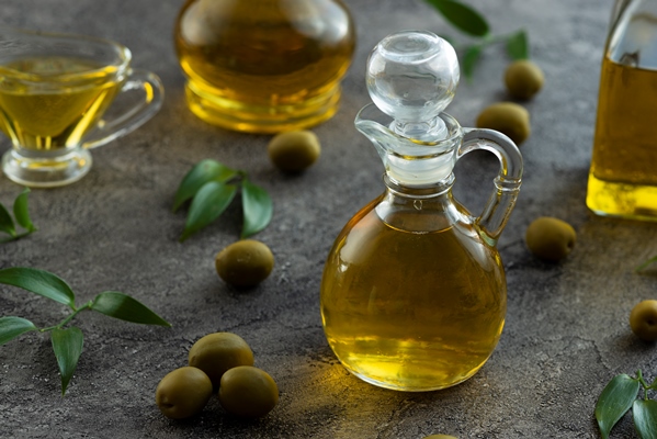 high view of bottles filled with olive oil on marble background - Суп-пюре из чеснока