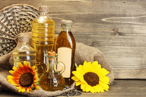 oil in bottles sunflowers and seeds on wooden background - Святочные кулинарные традиции: ржаной пирог с рыбой