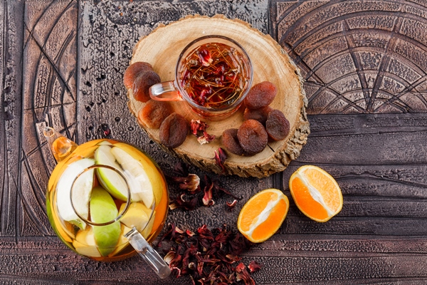 tea with dried fruits herbs fruit infused water orange wood in a cup on stone tile surface top view - Компот из яблок и вишни (школьное питание)