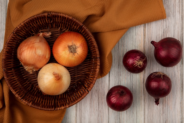 top view of healthy onions on a bucket on a cloth with red onions isolated on a grey wooden surface - Святочные кулинарные традиции: ржаной пирог с рыбой