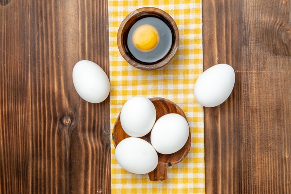 top view whole raw eggs on the brown wooden surface food breakfast wood eggs - Омлет с цветной капустой и микрозеленью кольраби (школьное питание)