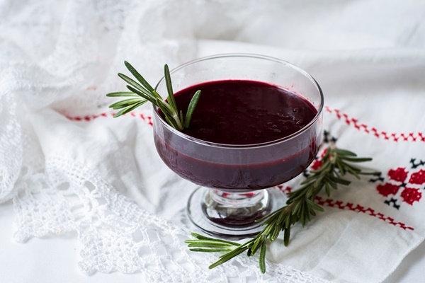 traditional national belarussian dessert kulaga kisel from frozen black currants with rosemary on a white table in glass glasses horizontal copy space - Кисель из брусники (школьное питание)