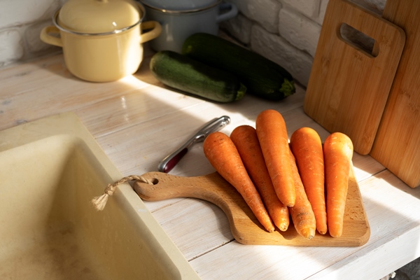 view of carrots on chopping board in the kitchen - Кулинарные традиции празднования Крещения Господня: вареники с картофелем, сыром и яйцом