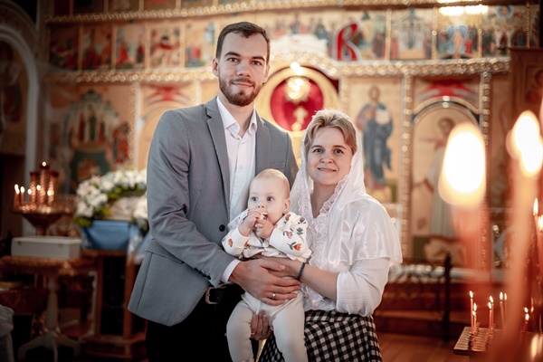 a family with children in an orthodox christian church or temple are praying or have come to the sacrament of baptism believers in a holy place introducing children to the faith - Кулинарные традиции празднования именин