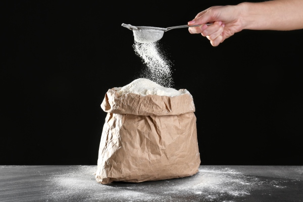 bag flour female hand with sieve dark background - Медовые пряники на молоке