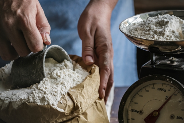 baker weighing flour on a scale - Борканник