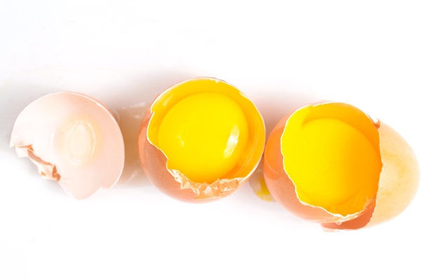broken chicken eggs isolated on white surface - Банановый пудинг с кэробом
