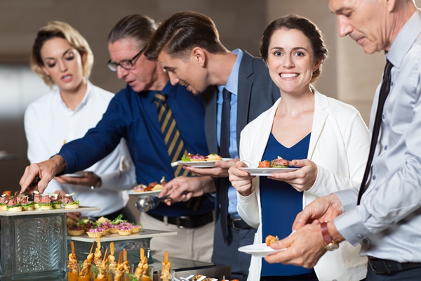 business people taking snacks from buffet table - Банкет