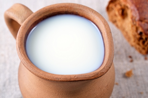 ceramic jug with milk and fresh bread close up rustic style - Варенец