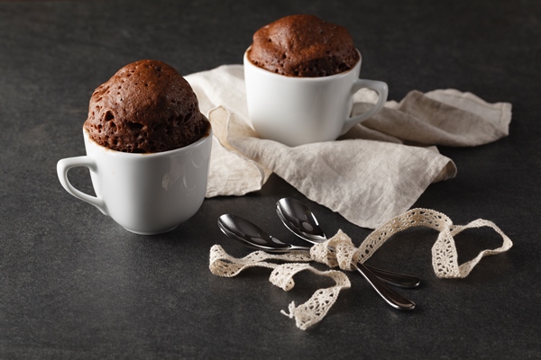 chocolate muffins on table surface rustic still life style - Кекс с кэробом в кружке
