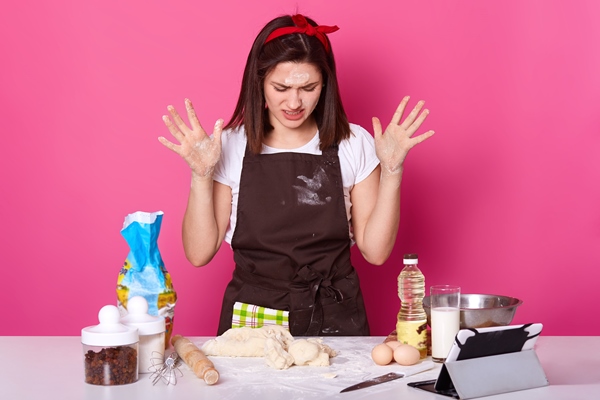 close up portrait tired housewife baker looks sad spends lots hours preparing easter cake has can make dough desired consistency wants stop baking isolated pink - Советы домашнему кондитеру: мука пшеничная