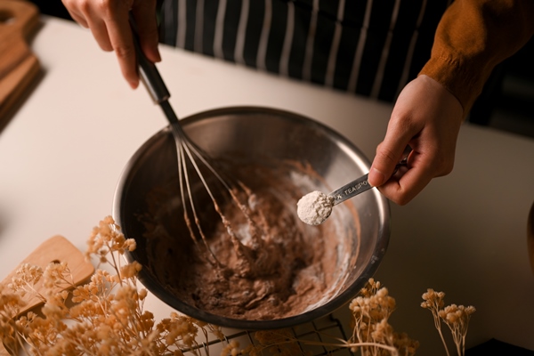 female prepare homemade sweet chocolate cookies dough adding some baking powder in the mixing bowl - Кекс с кэробом в кружке