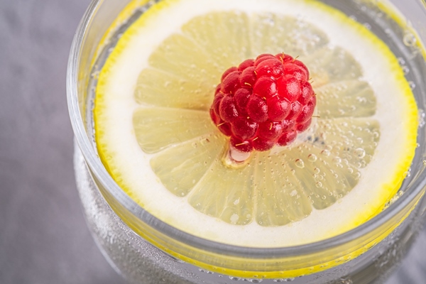 fresh cold sparkling water drink with lemon raspberry fruits in glass on stone - Хозяйке на заметку: словарь кондитера