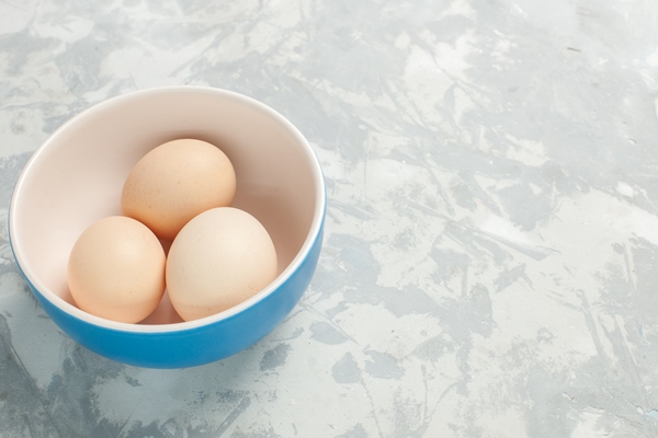 front view raw whole eggs inside little plate light white desk - Шарлотка медовая
