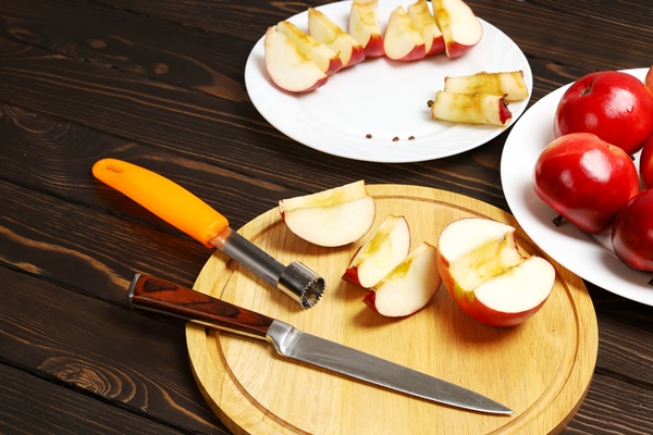 half juicy red apple remove cores then slice again into wedges with knife cutting board - Шарлотка простая