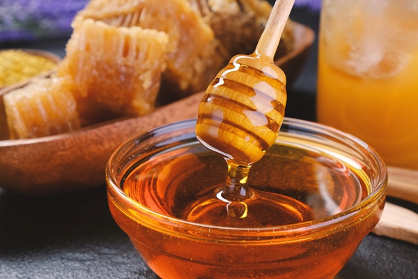 honey in glass jar with honey dipper - Ржаные банановые маффины с кэробом