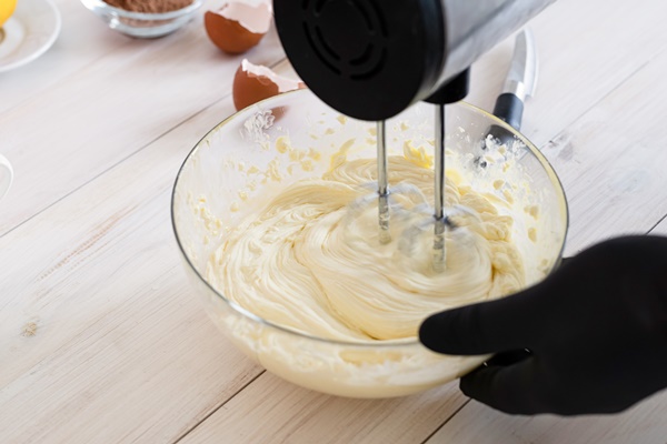 male hands mixing dough with electric mixer kitchen closeup - Американские вафли