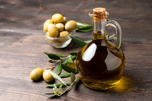 olive oil in a bottle and green olives - Запечённая тыква с шалфеем и чесноком