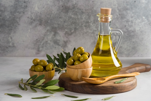 olives and olive oil on wooden board with bowl grey backround - Постный кекс с вишней и кэробом