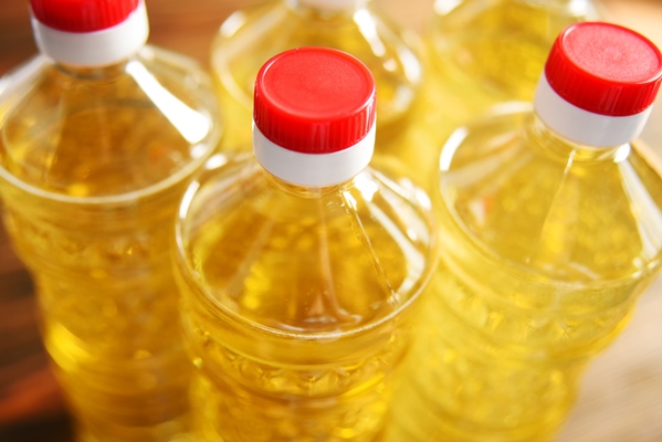 plastic bottles with sunflower oil on a wooden surface close up - Постная овсянка с кэробом