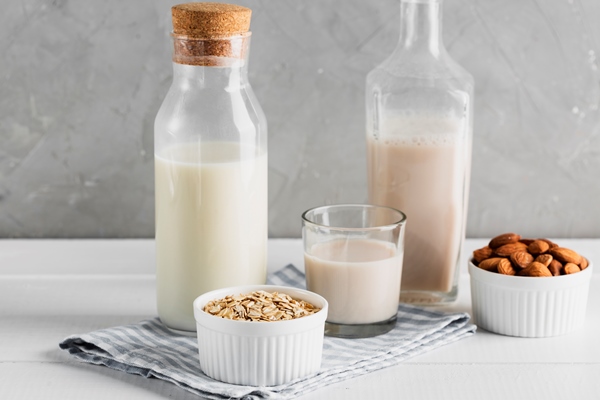 set of milk bottles and glasses with oatmeal and almonds - Постный пудинг с кэробом