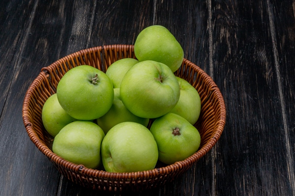 side view of green apples in basket on wooden background with copy space - Овсяный пирог с кэробом
