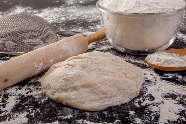 stages of making bread flour dough and loaf of bread on black background - Манты с рыбой и тыквой