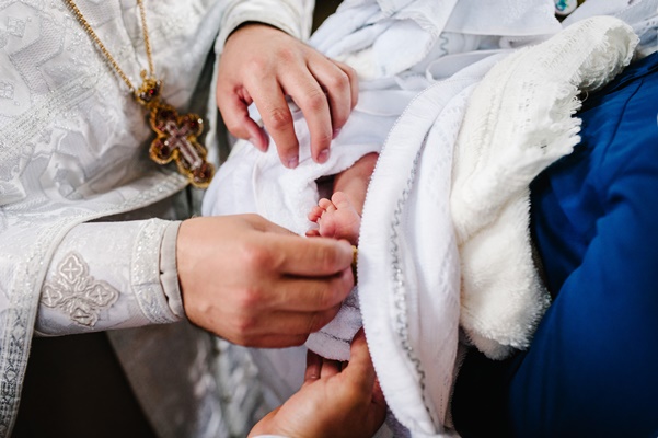 the sacrament of baptism newborn baby during christening and chrismation infant baby baptism in holy water - Кулинарные традиции празднования именин