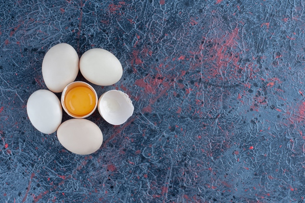 top view of fresh white chicken egg broken with yolk and egg white - Сахарная бабка