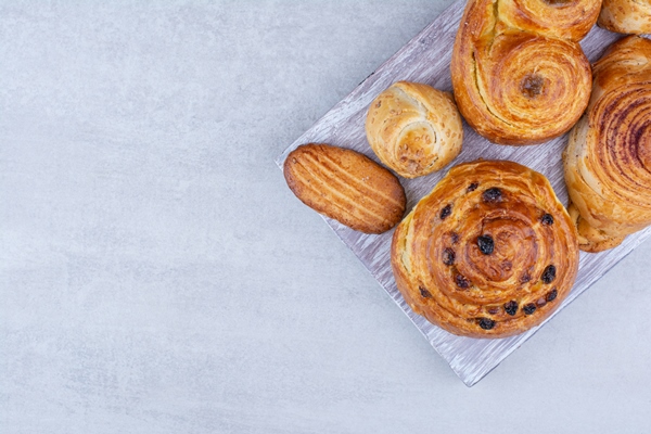 various sweet pastries and rolls with cookies on wooden board - Кулинарные традиции празднования именин