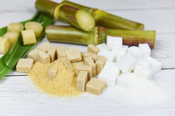 white and brown sugar cubes and sugar cane on wooden table - Суфле из каркаде