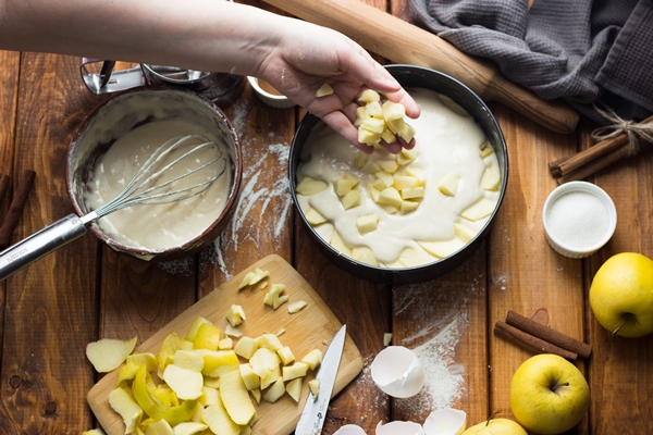 woman cooks apple pie wooden table process making pie - Шарлотка со сливочным маслом