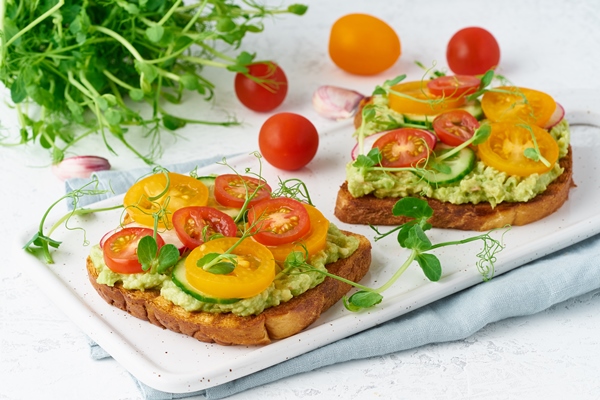 avocado toast with cherry tomatoes herbs breakfast closeup - Тосты с авокадо и помидорами черри
