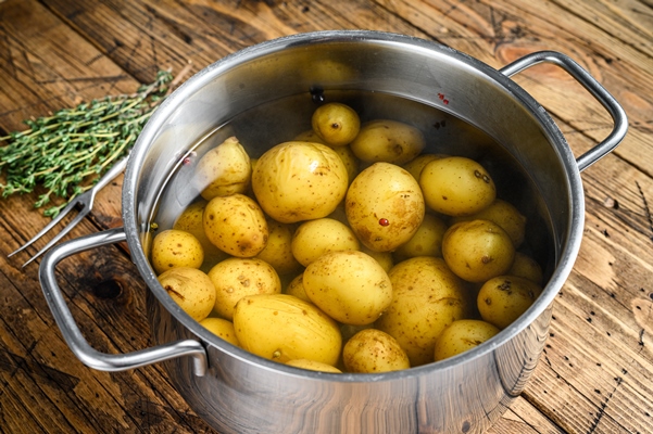 boiled baby potatoes in a saucepan - Картофель по-португальски