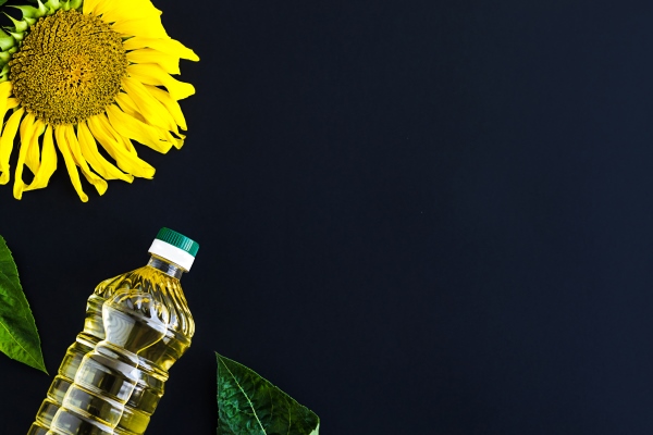 bottle golden sunflower oil yellow flower dark black background - Старорусские блины на молочной сыворотке
