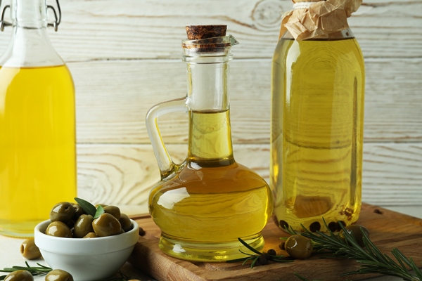 bottles olive oil against white wooden surface - Котлеты из нута