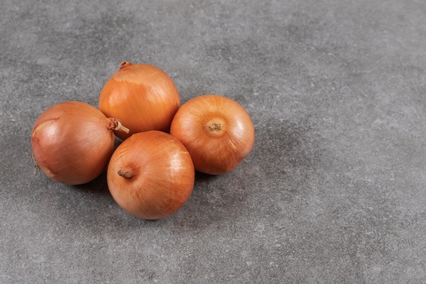 close up photo ripe onions grey table - Сельдь под лисьей шубкой
