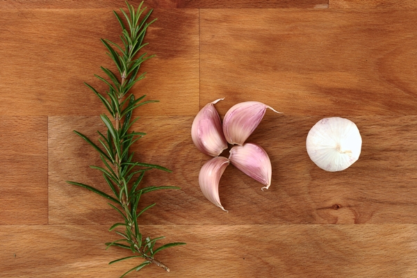 cloves garlic fresh organic rosemary wooden chopping board - Тарталетки с крабовыми палочками, сыром и ананасами