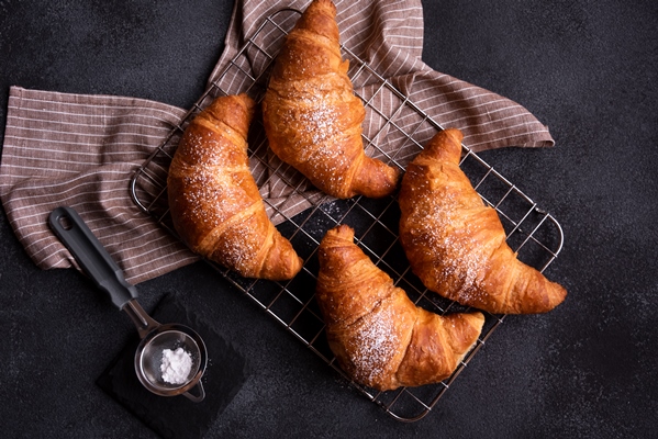 delicious freshly baked croissant dark background - Слоёные рожки