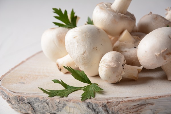 fresh white champignon mushrooms wooden board - Сельдь под лисьей шубкой