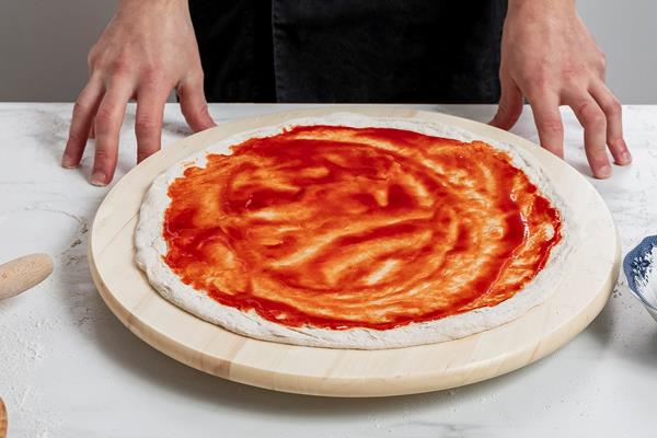 high angle man spreading tomato sauce pizza dough - Постная грибная пицца