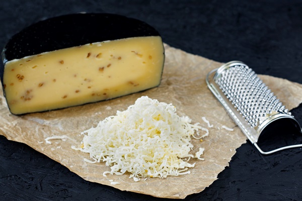 kachotta cheese sliced black background with grater - Картофельная запеканка "Особая"
