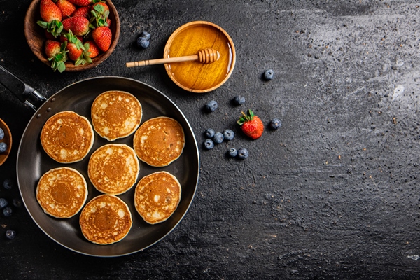 pancakes frying pan with fresh berries honey - Банановые оладьи на аквафабе, постный стол