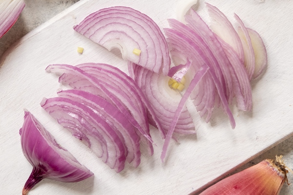 sliced red tropea onions white board top view traditional local south italian vegetable cooking process home kitchen - Запеканка из сыра и лука