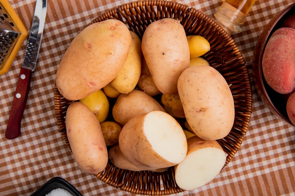 top view potatoes basket with knife plaid cloth background - Постные драники с брусничным соусом