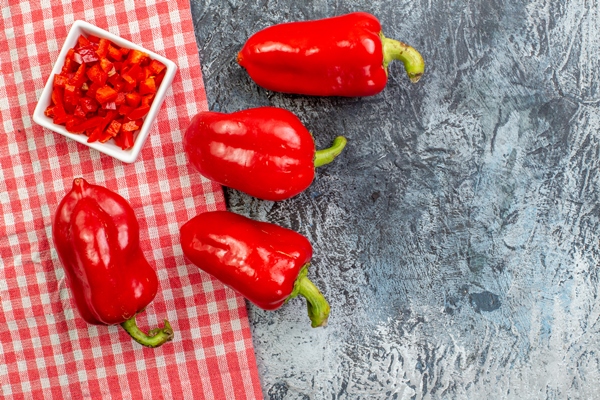 top view red bell peppers light grey table - Кускус с помидорами и сладким перцем