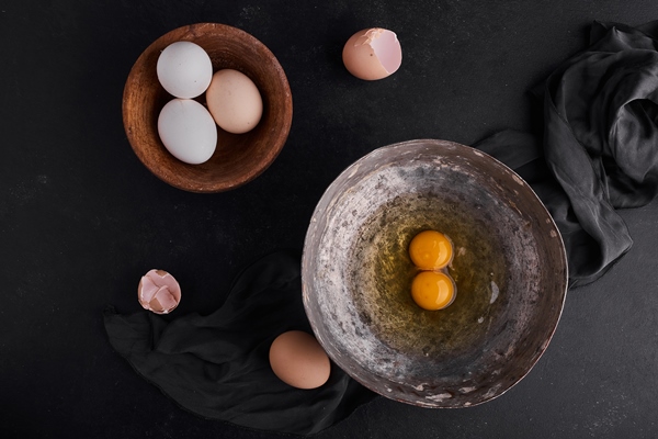 whole eggs yolks wooden metallic plates top view - Булочки с корицей