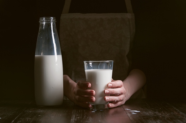 woman farmer pours milk into glass - Дрожжевые ажурные блины