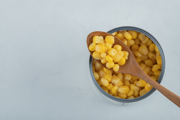 wooden spoon full popcorn seeds white - Салат с креветками, кукурузой и яйцом